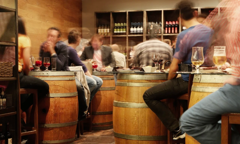 mensen drinken bier aan tonnen